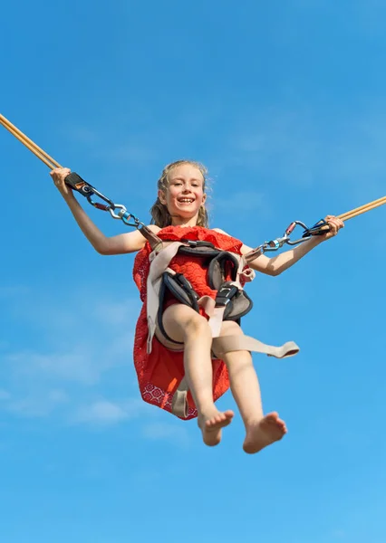 Little girl on bungee trampoline with cords. Place for text. — Stock Photo, Image