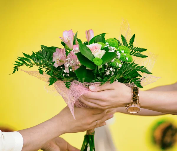 Woman giving bouquet of flowers to another woman. — Stock Photo, Image