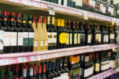 Raflar süpermarkette alkollü içecekler ile bulanık görüntü.