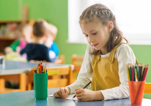 Dessin de petite fille avec crayon à la maternelle . — Photo