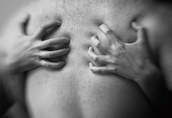 Couple in passion. Female hands on male back. Black and white. Stock Photo
