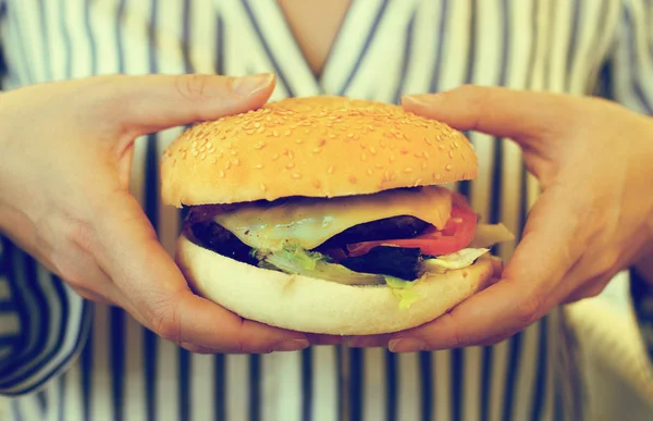 Руки женщины держат гамбургер . — стоковое фото