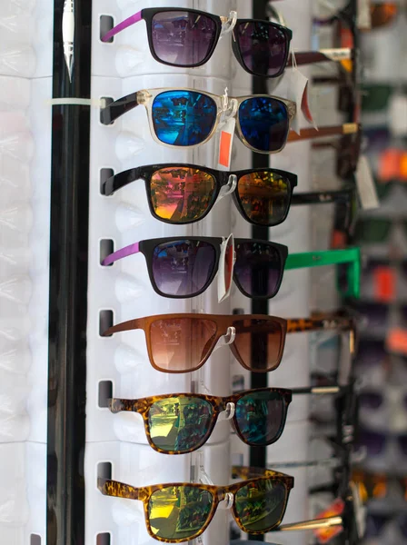 Perchero giratorio con gafas de sol de colores en el mercado . — Foto de Stock