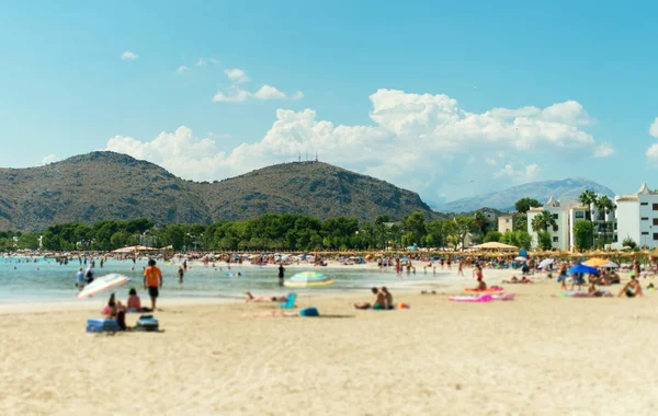 Viele Menschen ruhen sich am Sommerstrand aus. Unscharfes Bild. — Stockfoto