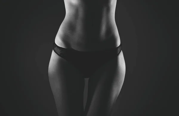 Vorderseite des schlanken weiblichen Körpers in schwarzen Höschen. schwarz-weiß. — Stockfoto