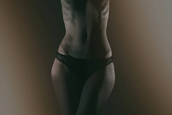 Vorderseite des schlanken weiblichen Körpers in schwarzen Höschen. — Stockfoto