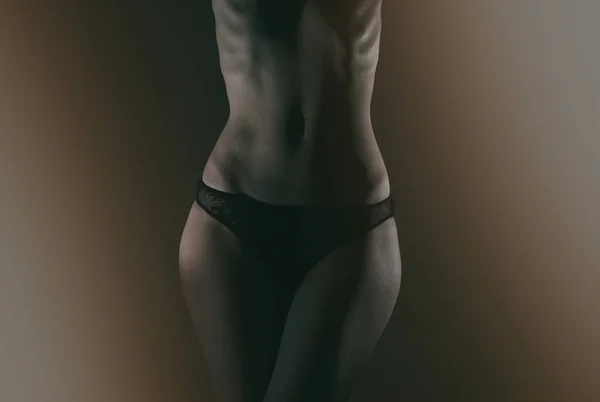 Vue de face du corps féminin mince en culotte noire . — Photo