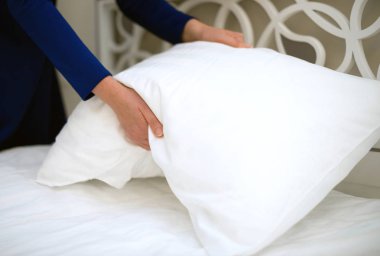 Oda servisi. Otel odasında yatak yapan kadın..