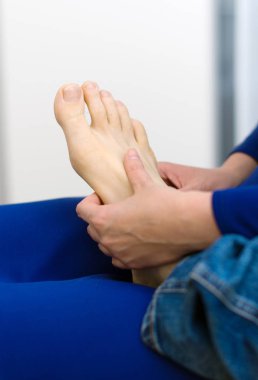 Evde adam kadının ayak masajı yapması.