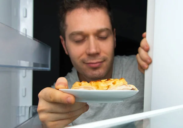 Man taking food out of refrigerator at night. — Stock Photo, Image