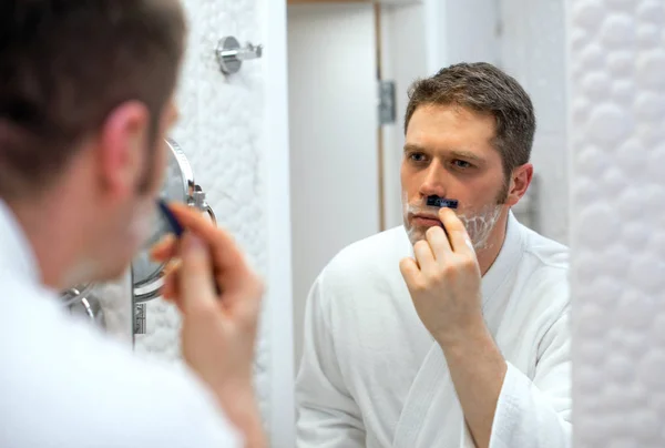 Handsome man shaving in bathroom. — Stock Photo, Image