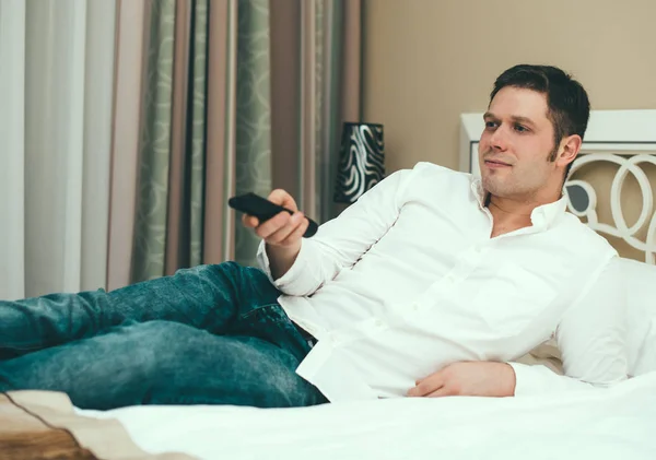 Hombre viendo la televisión en la habitación del hotel . —  Fotos de Stock