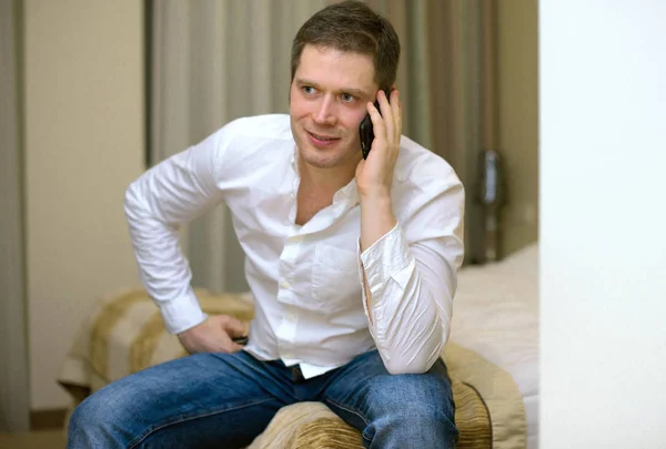 Homme avec téléphone portable dans la chambre d'hôtel . — Photo