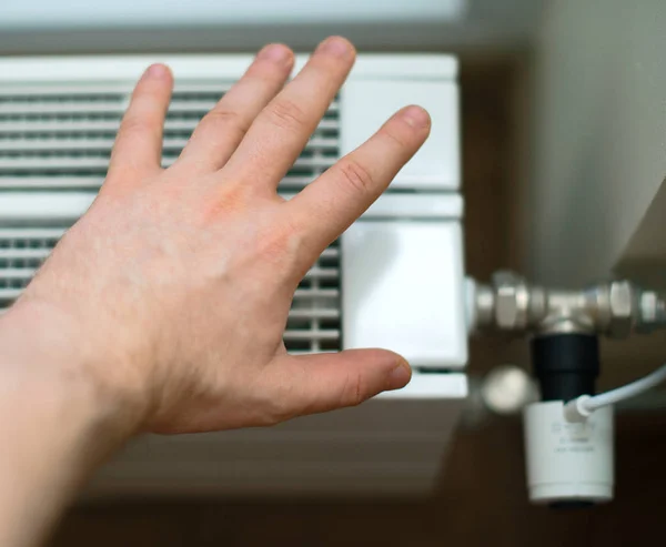 人間の手のラジエーターを暖房の温度をチェック. — ストック写真