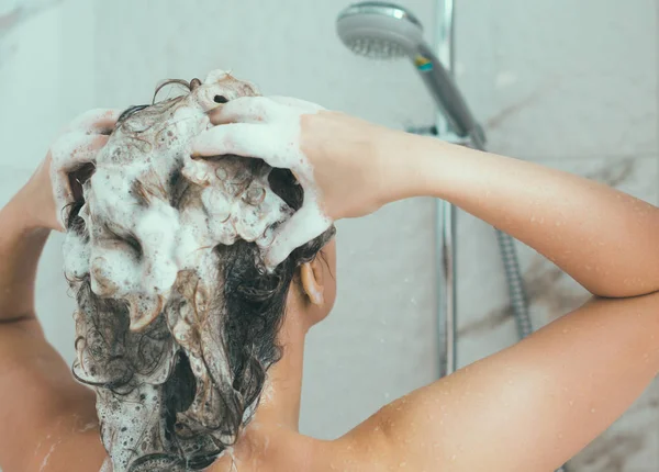 Kvinna som tvättar hennes huvud i duschen. — Stockfoto