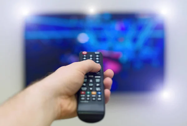 Masculino mão segurando tv controle remoto . — Fotografia de Stock