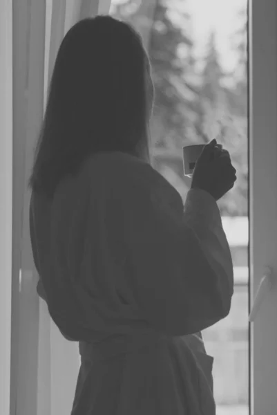 Frau genießt ihren Morgenkaffee am Fenster. — Stockfoto