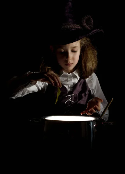 Маленька дівчинка в костюмі відьми готує зілля . — стокове фото