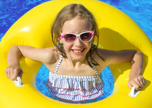 Portrét holčička s nafukovací gumový kroužek v bazénu. — Stock fotografie
