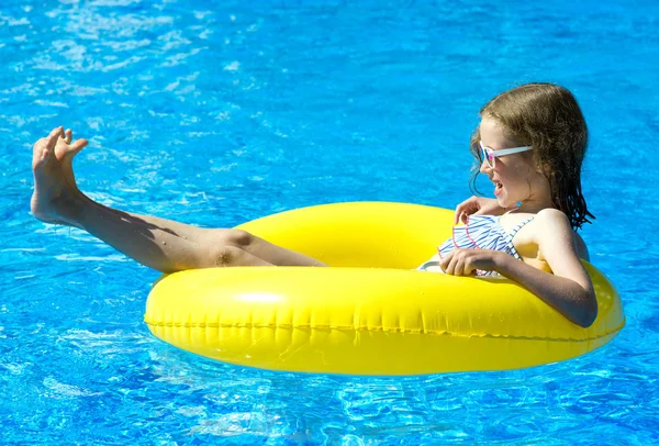 Menina pequena com anel de borracha inflável que se diverte na piscina . — Fotografia de Stock