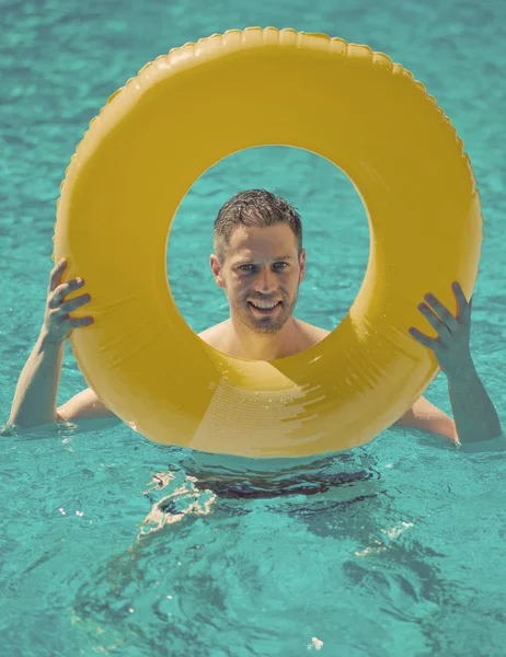 Człowiek z pierścieniem nadmuchiwane gumowe w basenie. — Zdjęcie stockowe