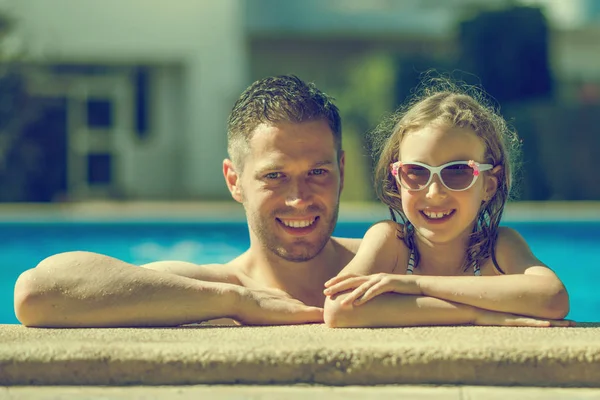 Smiling little girl with her dad in swimming pool. — Stock Photo, Image