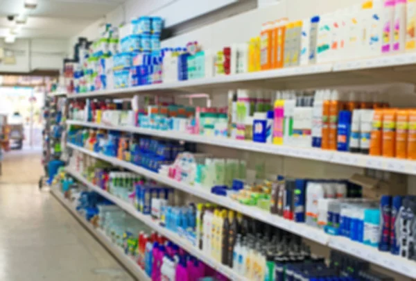 Blurred image of shelves with shampoos and household chemicals in supermarket.