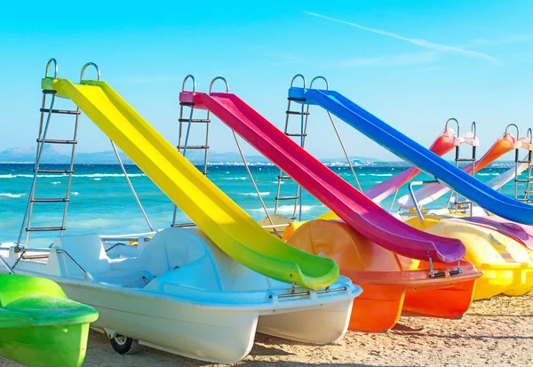 Pedal-boats with water slides on the beach. — Stock Photo, Image