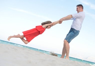 Baba ve kız sahilde iplik.