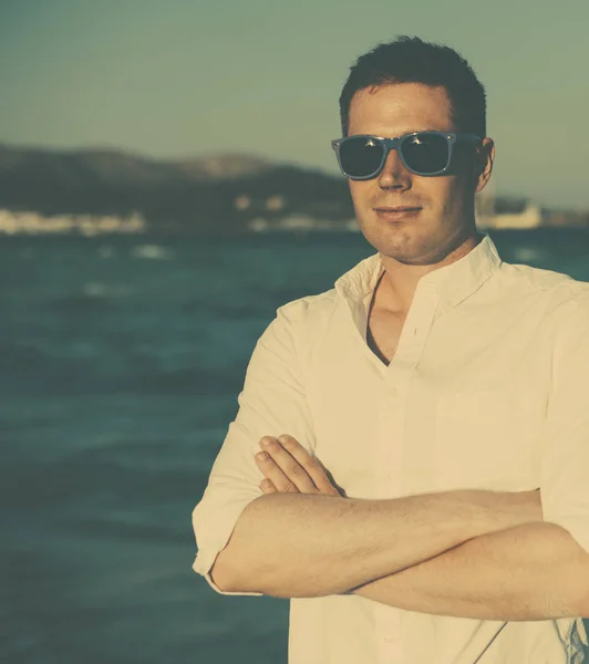 Bel homme dans des lunettes sur la plage . — Photo