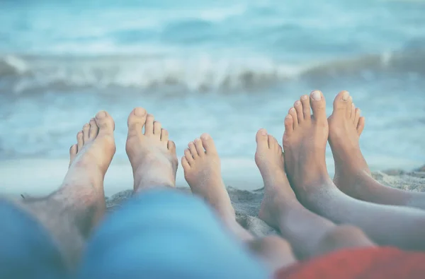 Três pares de pés na areia. Família em férias . — Fotografia de Stock