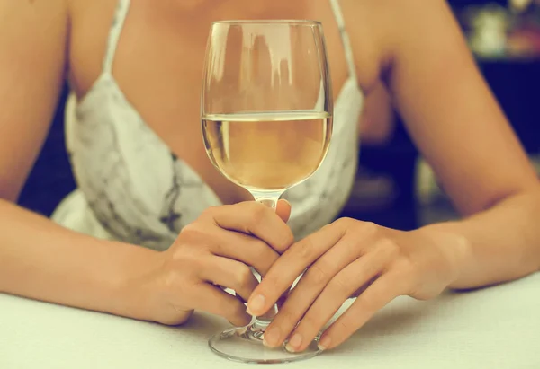 Žena sedí u stolu s Sklenka vína. — Stock fotografie
