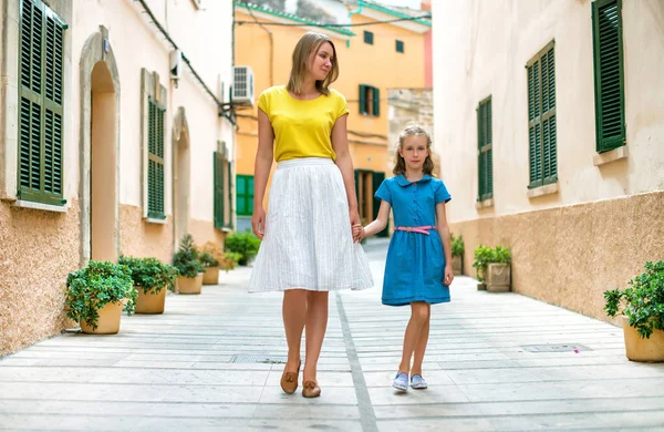 Kleines Mädchen und ihre Mutter gehen die Straße hinunter. — Stockfoto