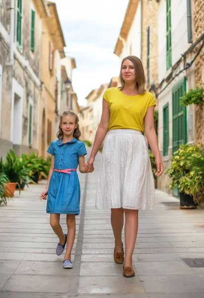 Bambina e sua madre che camminano per strada . — Foto Stock