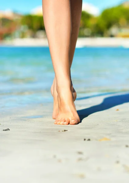 Närbild av kvinnors ben på stranden. — Stockfoto