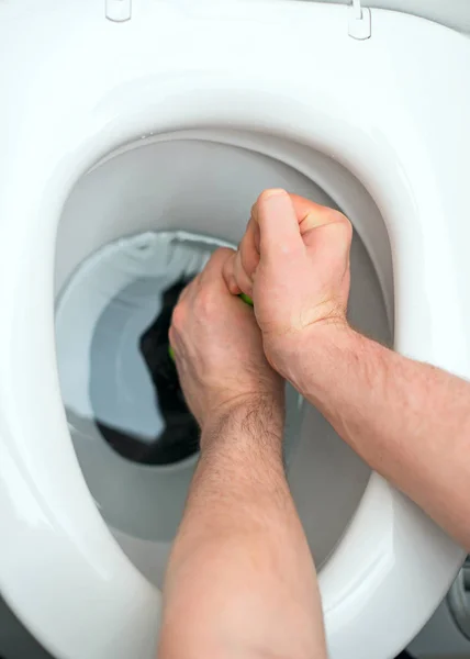 Plumber repairing toilet with hand plunger. — Stock Photo, Image