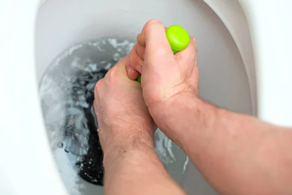 Plumber repairing toilet with hand plunger. — Stock Photo, Image