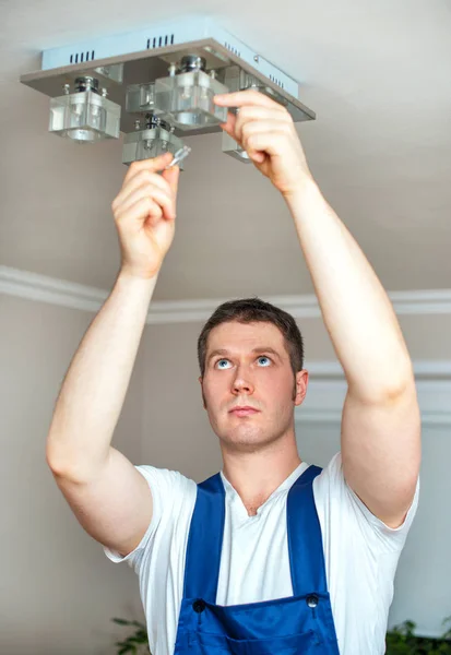 Eletricista masculino mudando lâmpada . — Fotografia de Stock