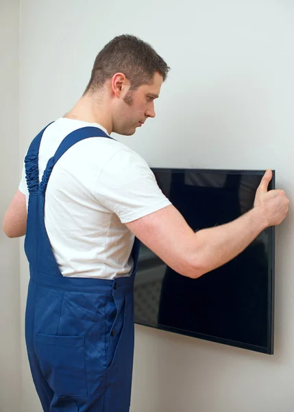 Ο άνθρωπος τοποθέτηση τηλεόρασης σε τοίχο. — Φωτογραφία Αρχείου