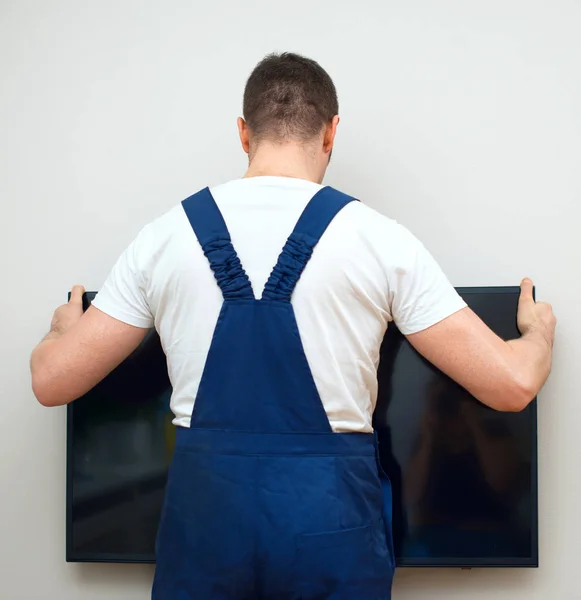 Mann montiert Fernseher an die Wand. — Stockfoto