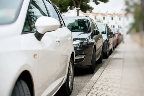 Carros estacionados ao longo da rua . — Fotografia de Stock