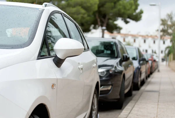 Carros estacionados ao longo da rua . — Fotografia de Stock