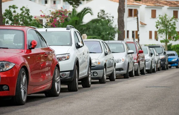 Carros estacionados ao longo da rua . — Fotografia de Stock