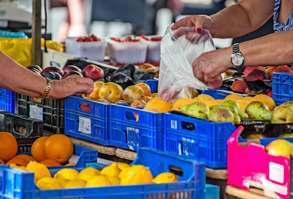 Elderly woman buying fruits on the market. — Stock Photo, Image