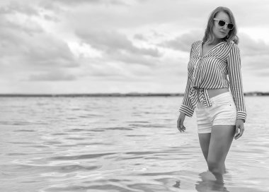 Denizde duran genç kadın. Siyah ve beyaz.