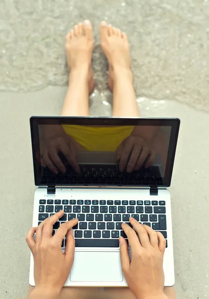 Girl working on laptop on the beach. Top view. — Stock Photo, Image