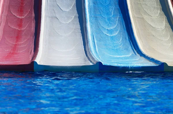 Corrediças de água plásticas coloridas no parque aquático . — Fotografia de Stock