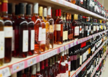 Raflar süpermarkette alkollü içecekler ile bulanık görüntü.