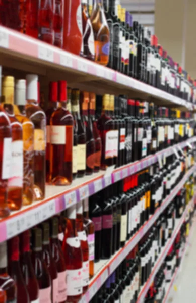 Imagem turva das prateleiras com bebidas alcoólicas no supermercado . — Fotografia de Stock