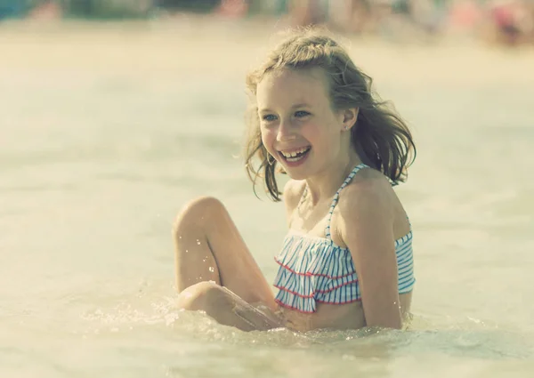 Lilla flickan har roligt i havet. — Stockfoto